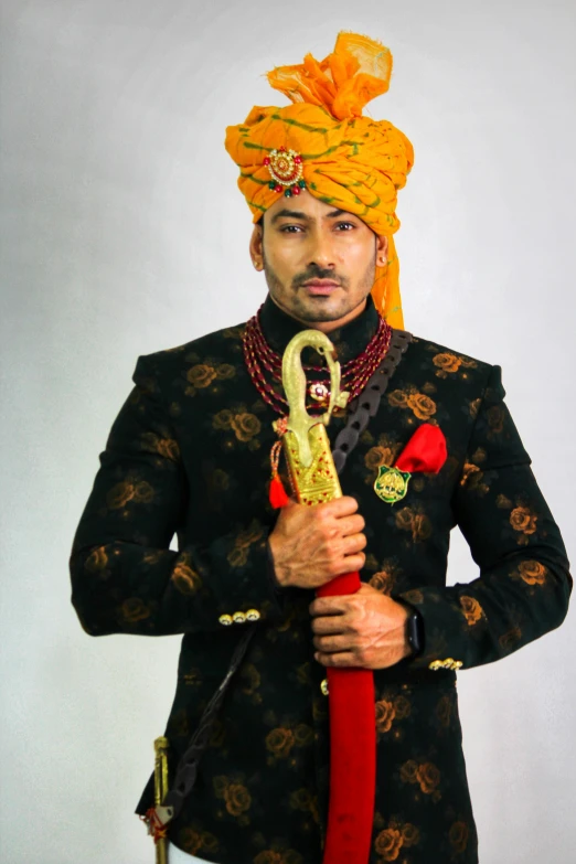 a man dressed in indian garb holding an umbrella