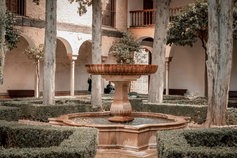 a fountain inside of a building surrounded by trees