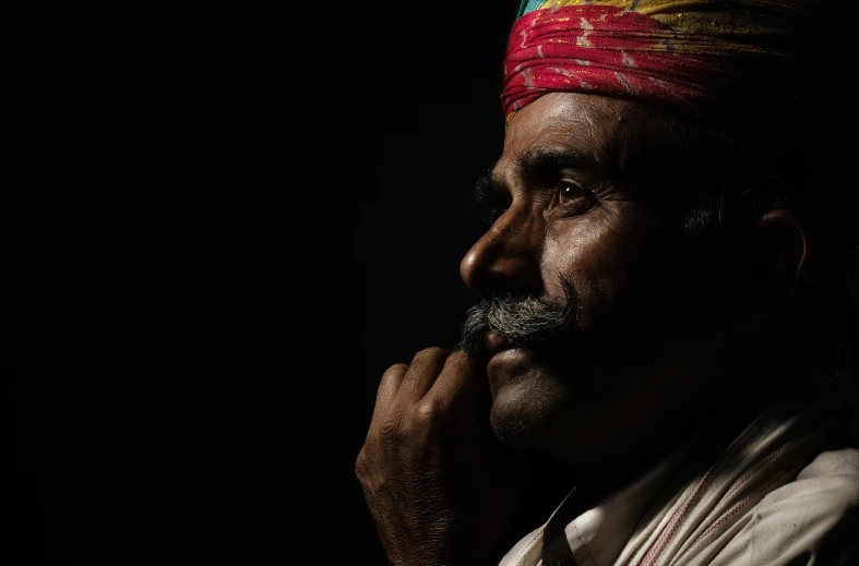 a man in colorful head band stares into the distance