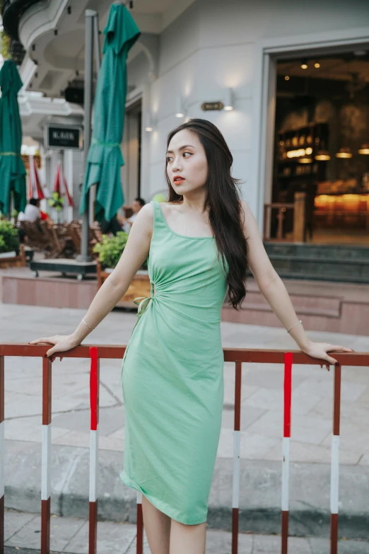 a young woman standing near the rails in an urban area