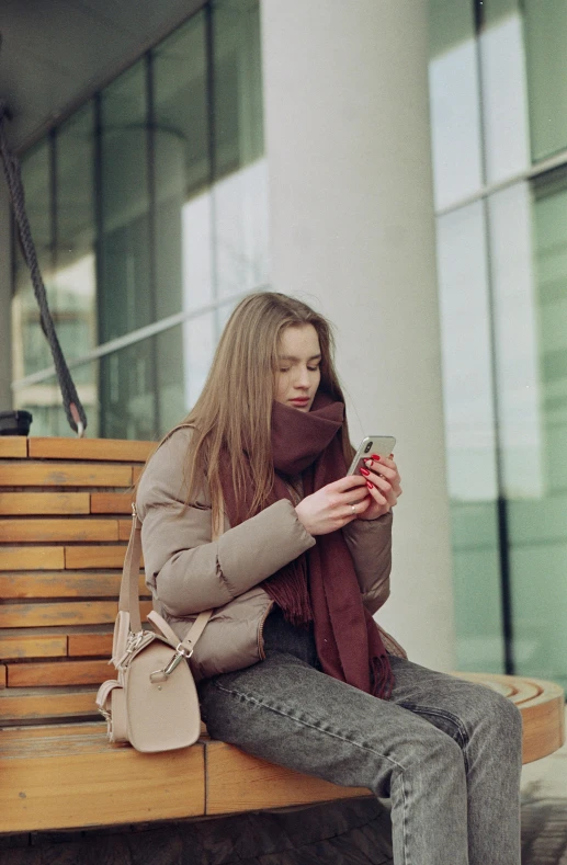 the woman is sitting on the bench with her handbag