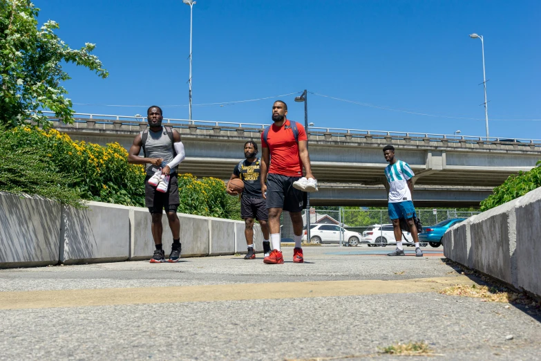 three people standing on the sidewalk and one has a phone