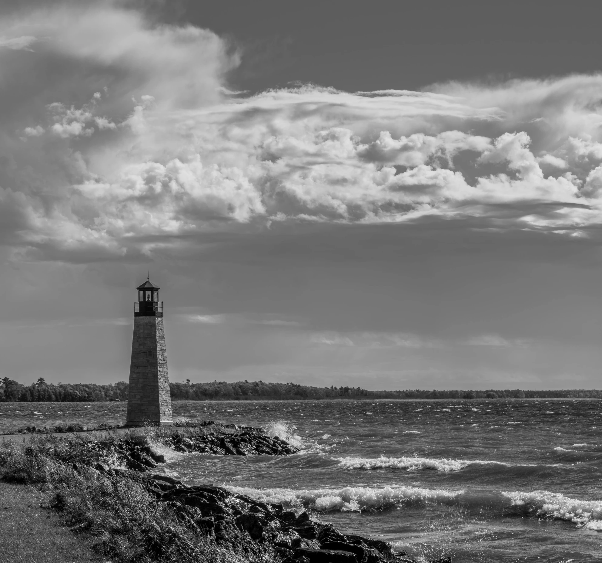 a light house with a water front view in the background