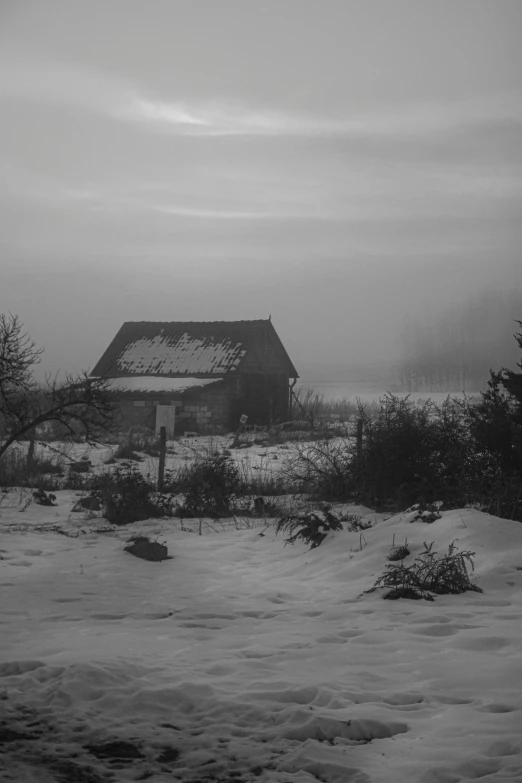 an old barn sitting in the middle of snow