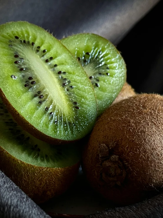 a kiwi and two halves on a table