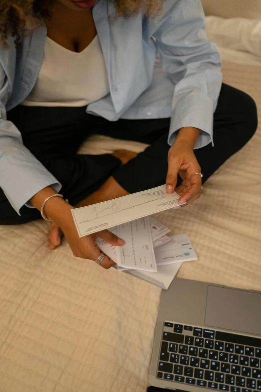 the woman is sitting on her bed with a lot of mail