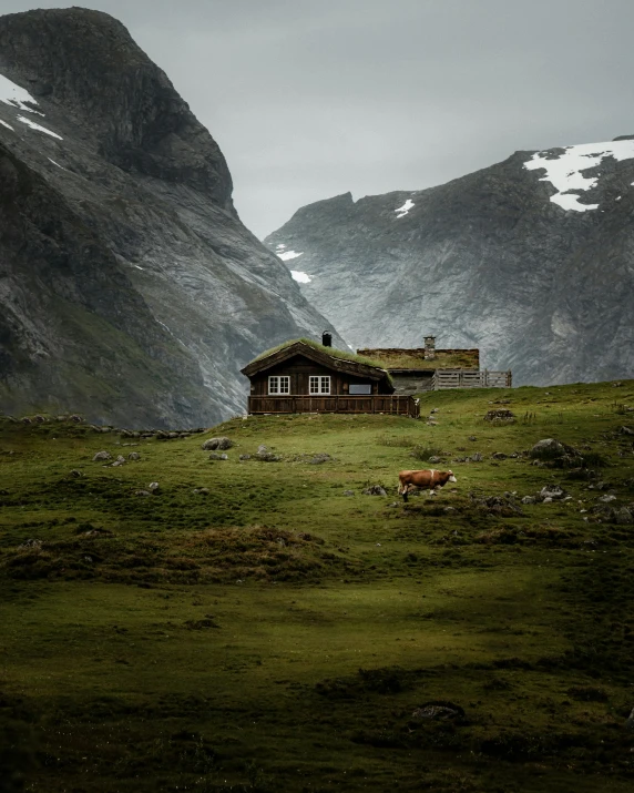 a cabin in a mountain valley surrounded by mountains