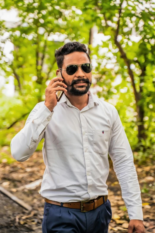 a man is talking on the phone while wearing sunglasses