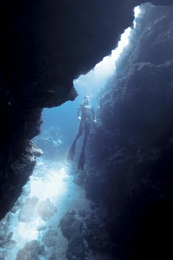a person is scubaing in the water through a cave