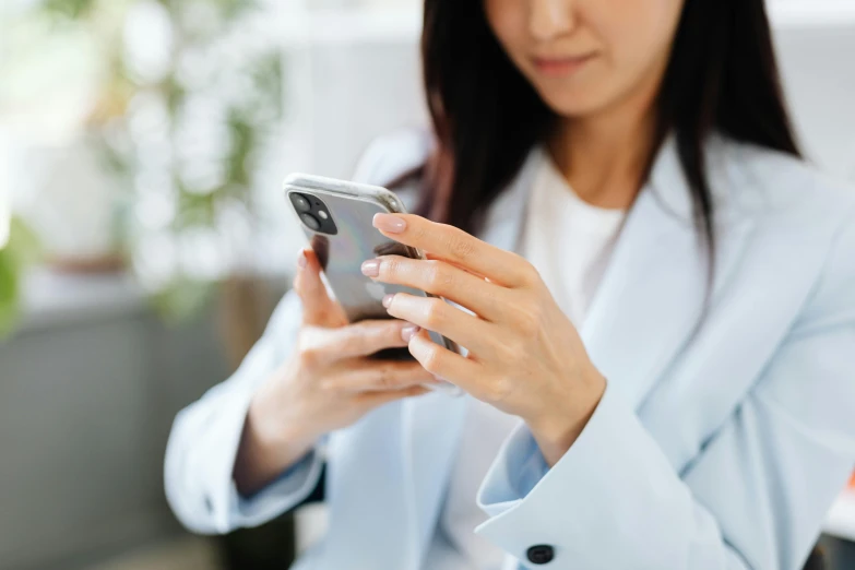 the woman is holding a cell phone in her hands