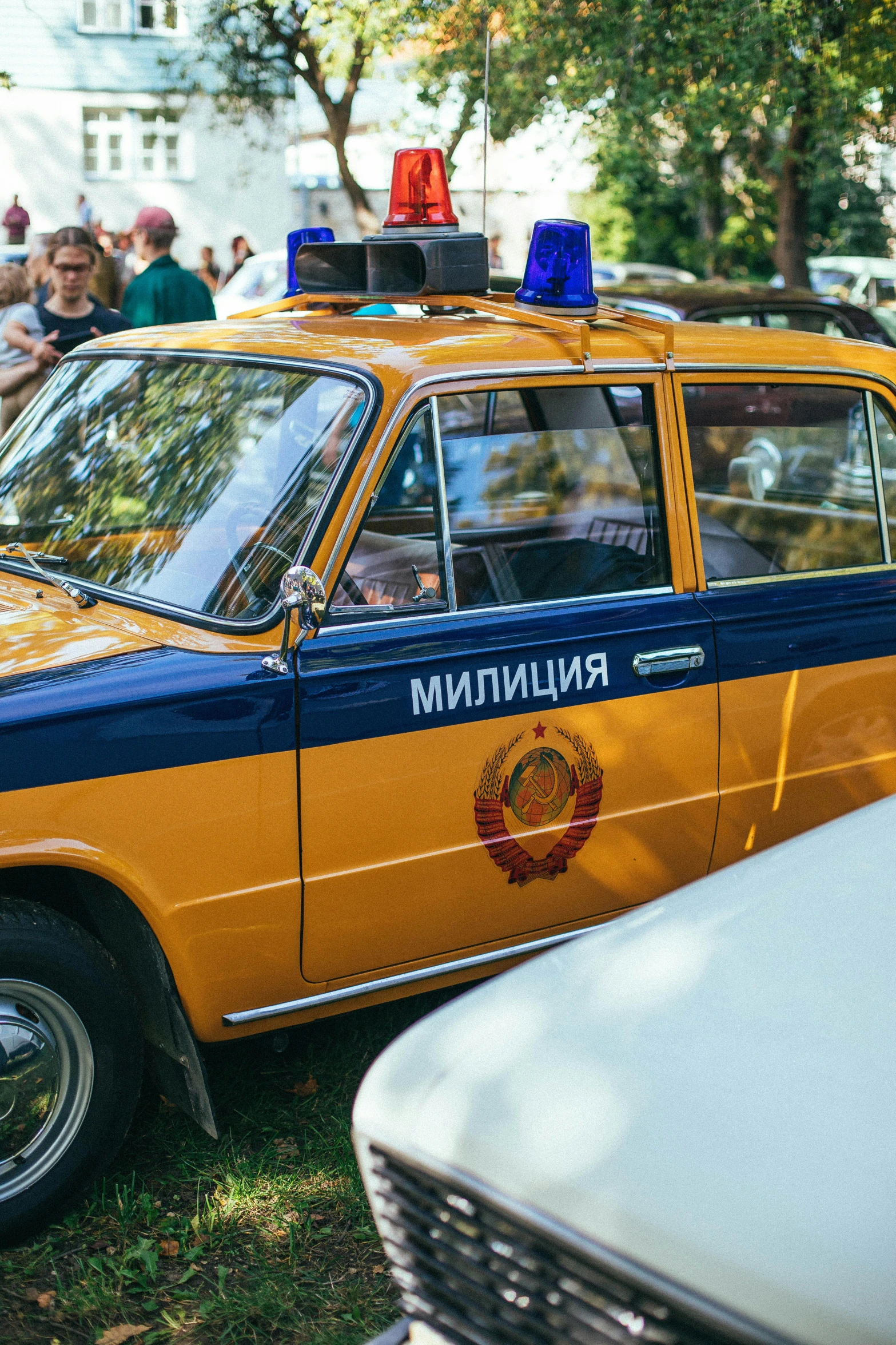 an orange and blue police car sitting in the grass