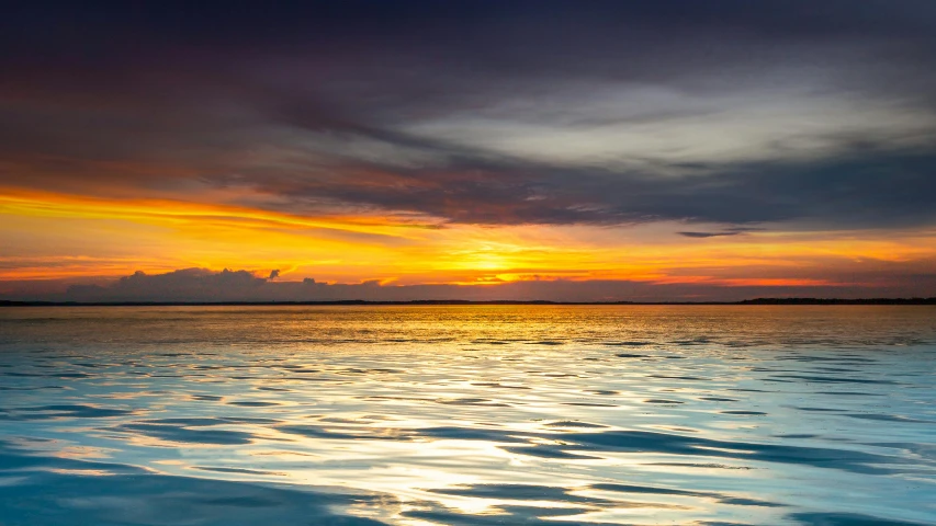 an ocean during the sunset with water reflections