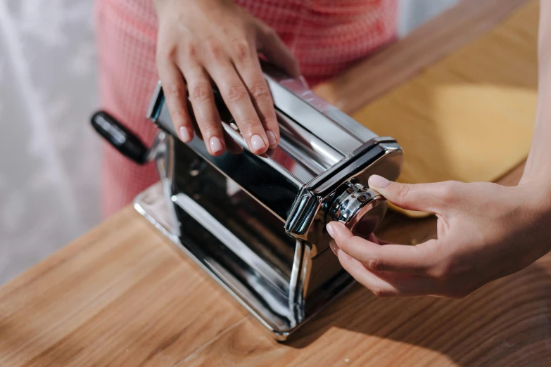 woman opening up her chrome toaster while at a counter