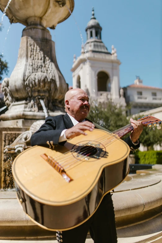 a man in a suit holding an acoustic guitar