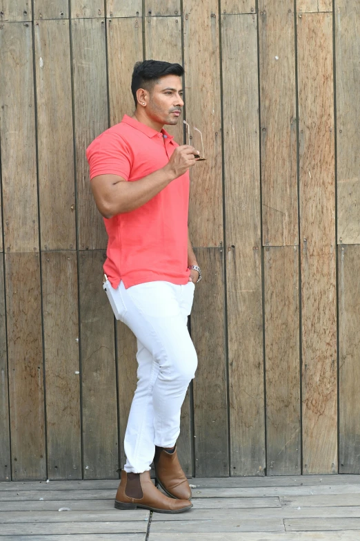 a man is posing on the ground, wearing jeans and a red shirt