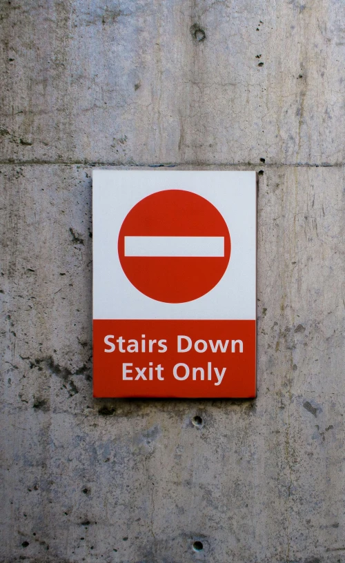 red and white sign saying stairs down exit only