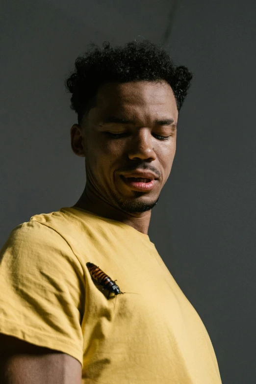 a young black man in a yellow shirt with a black kite