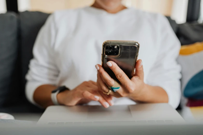 the woman is using her cell phone at the table