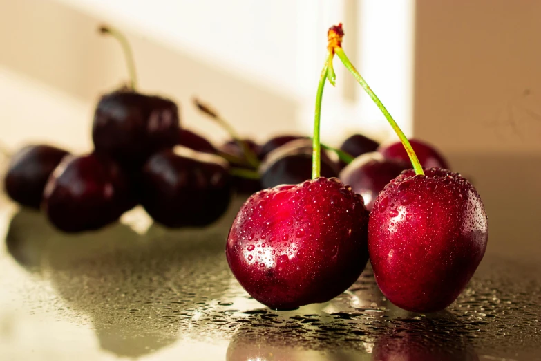 some red cherries are on a counter with water