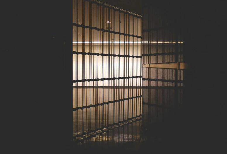 an empty room with bars at the end