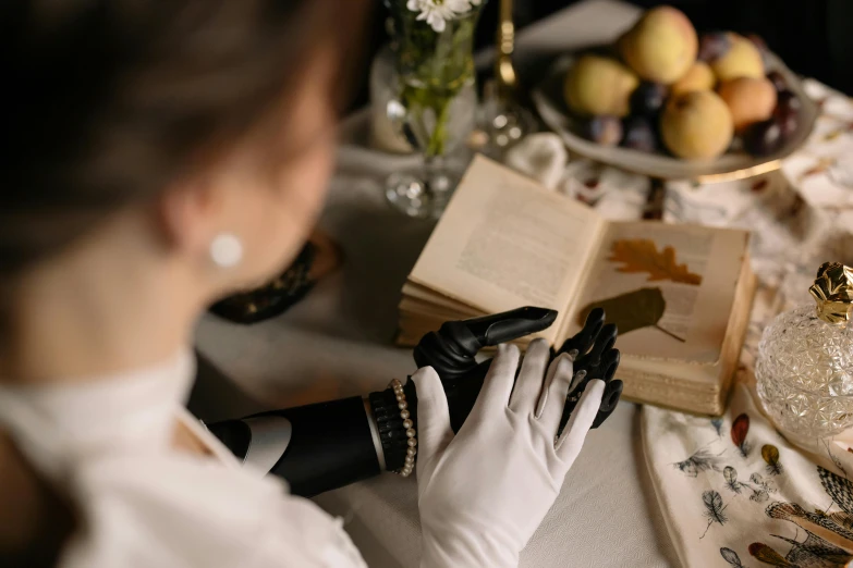 a lady is shown reading a book with a black gloves