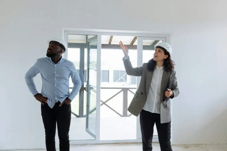 a woman standing behind a man while he holds his hands up