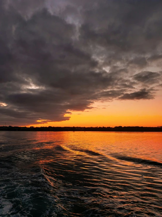 the sun is setting over a calm ocean