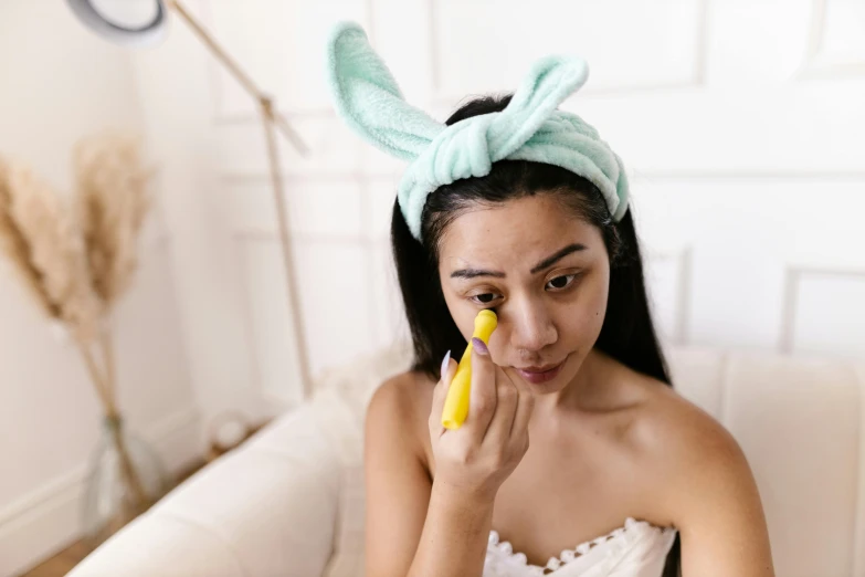 a woman in bunny ears holding a banana