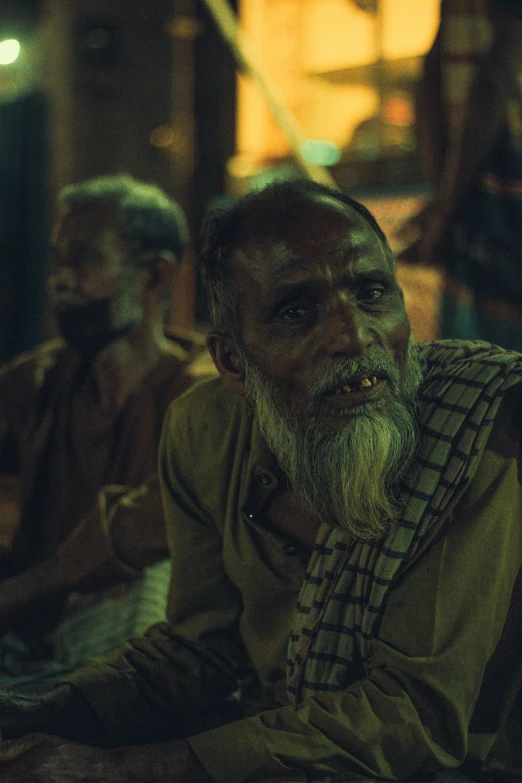 a man sitting in front of a window at night