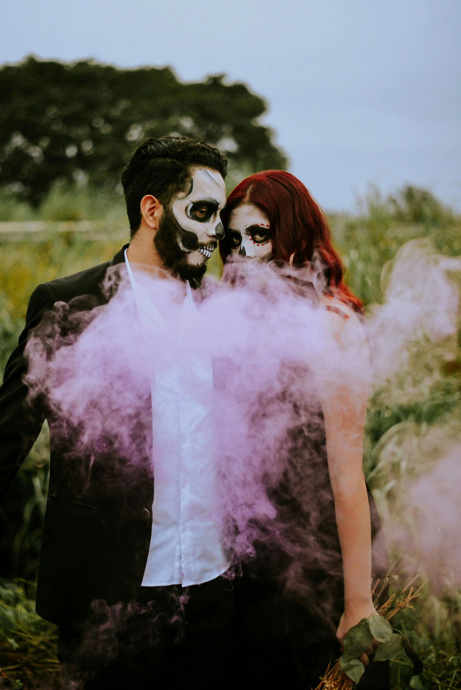 a man and a woman in white makeup make faces for the camera