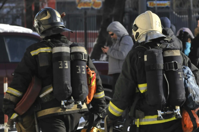 two firefighters walking in a line on the street