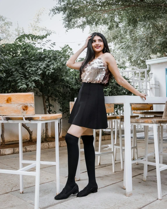 a woman is posing near the table in front of the house