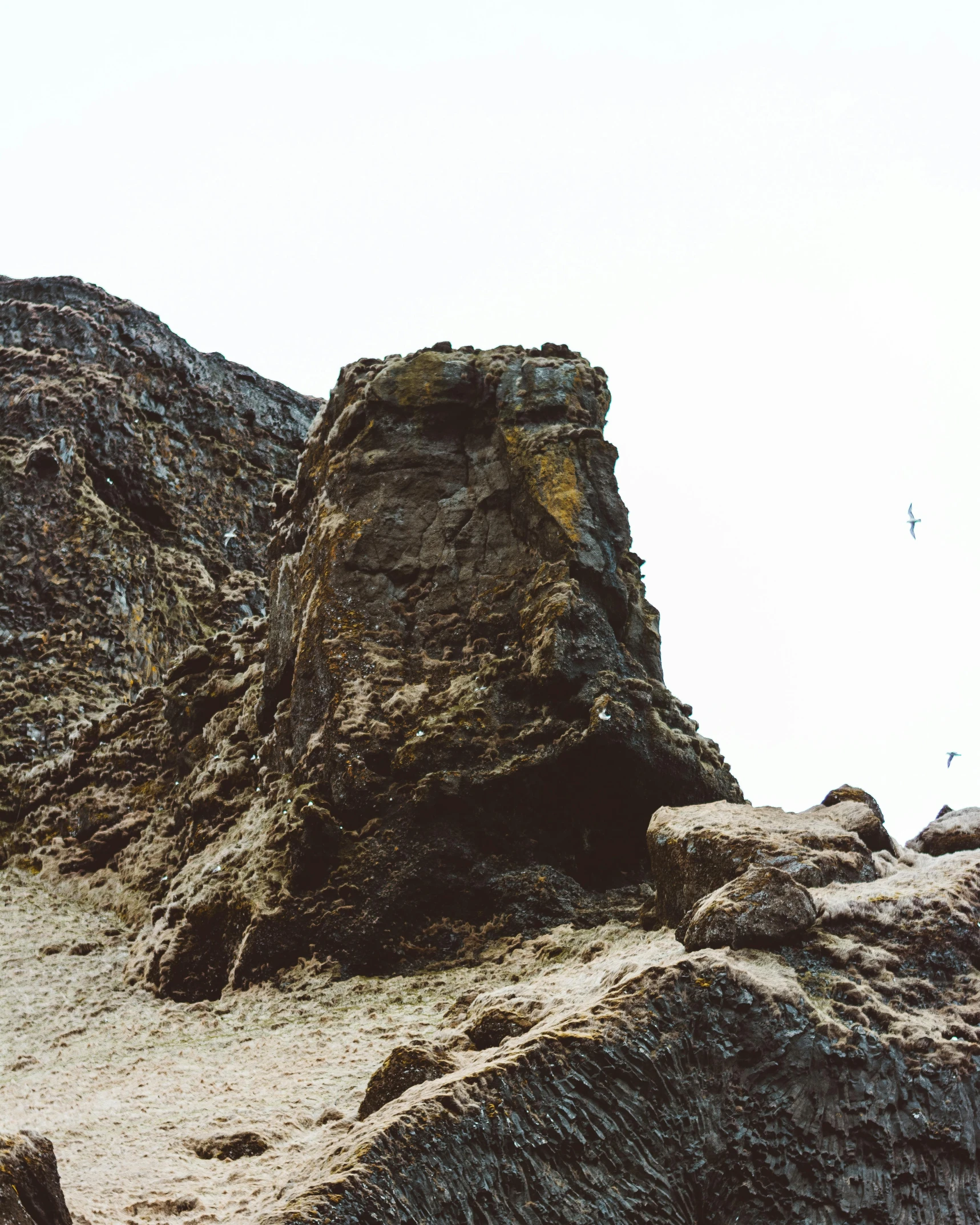 some very big rocks and dirt by a mountain