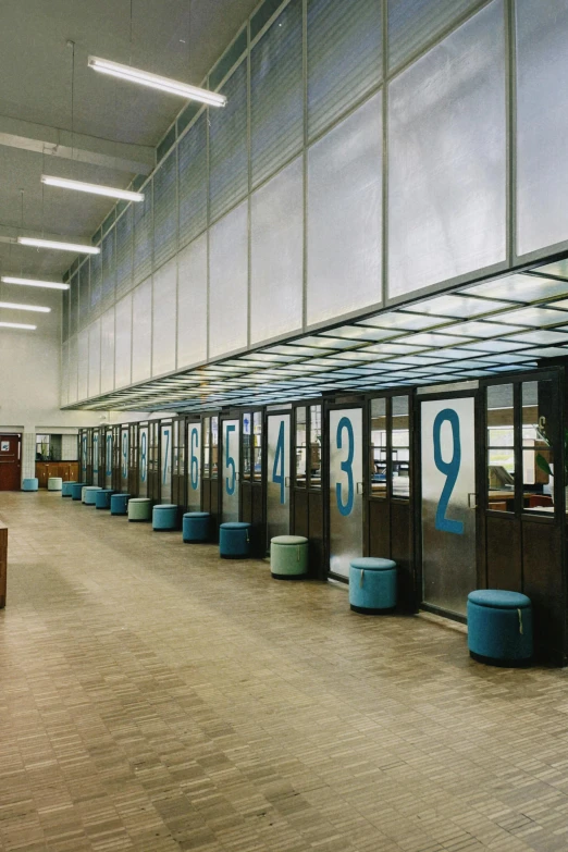 a building with a number on the wall and several empty blue chairs