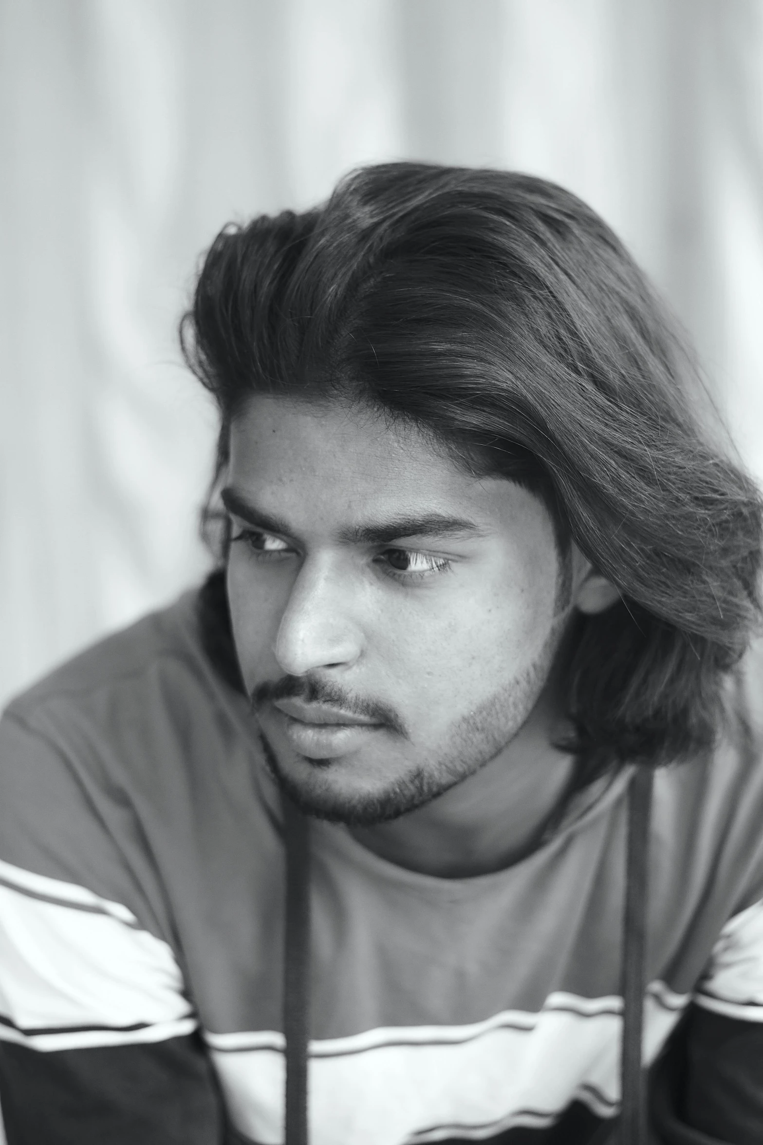 a black and white po of a young man wearing a striped shirt