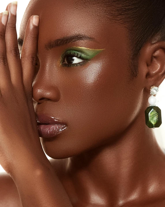 a woman wearing green and gold make up