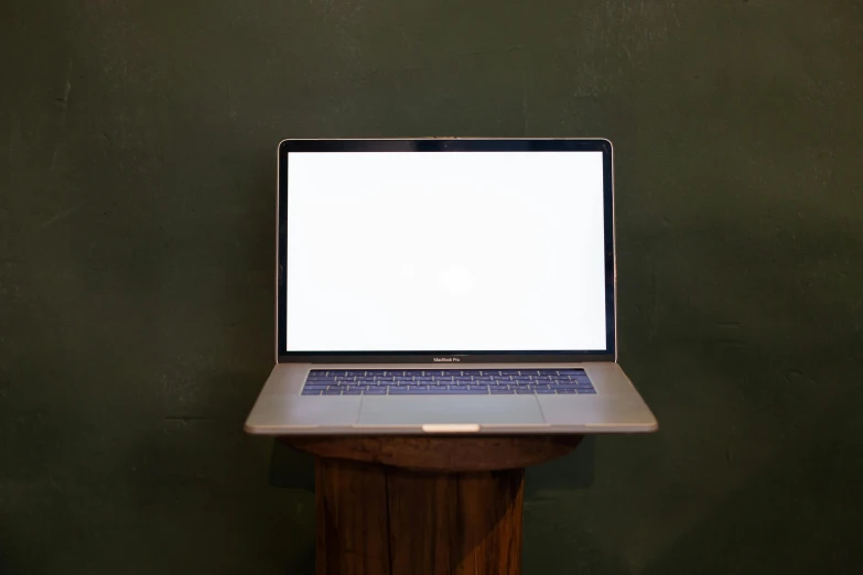 a laptop computer on top of a wooden table