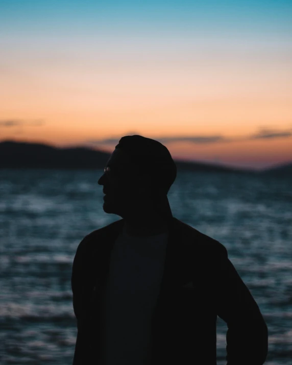 man looking at the water during sunset