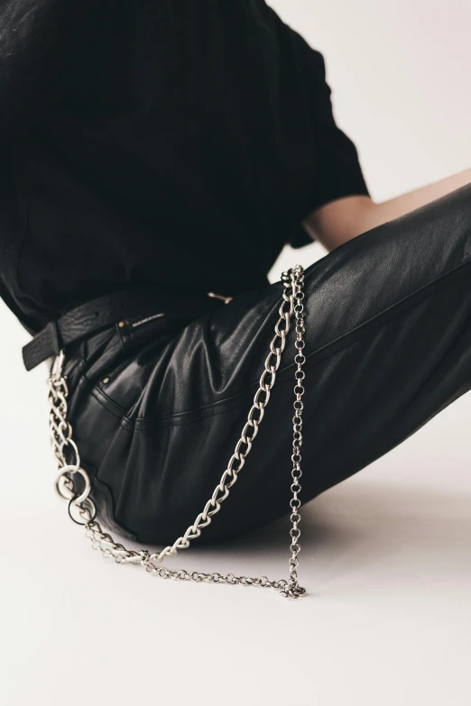 person sitting on ground holding a chain around their ankles
