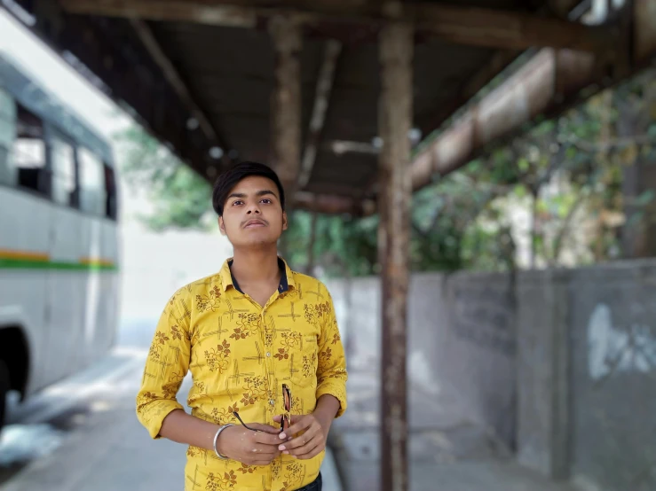 a man standing by a bus stop smiling