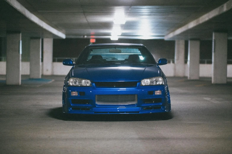 a very pretty blue car parked in a parking garage