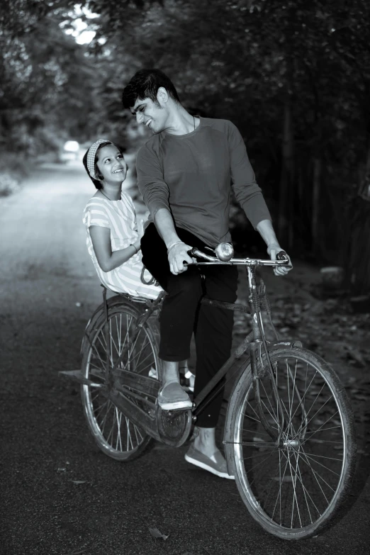 a man and a woman ride a bicycle