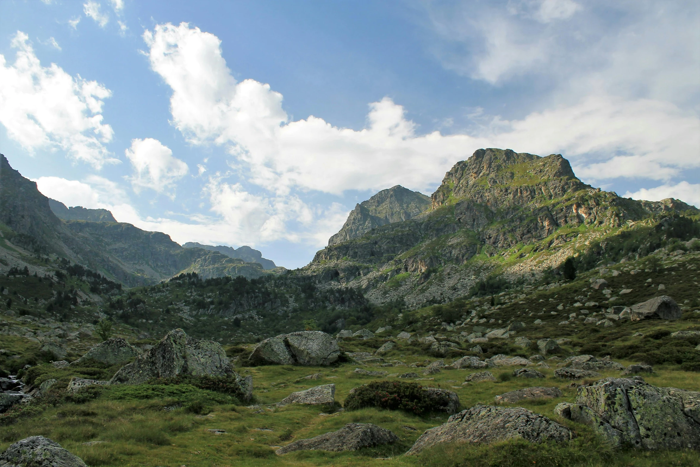 mountains and rocks are shown against the cloudy sky