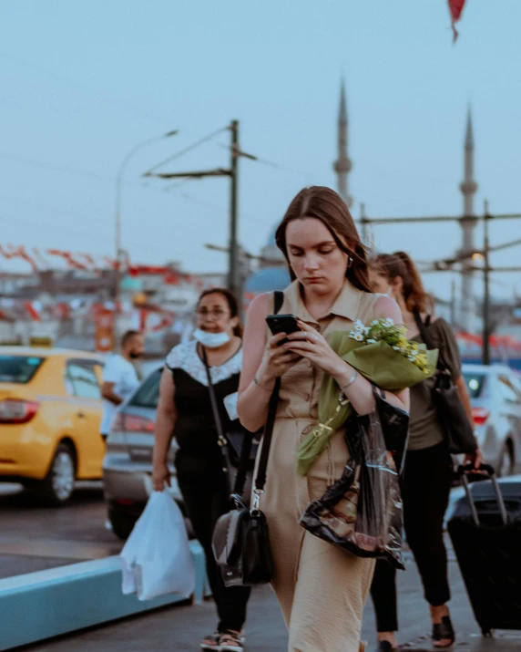 a girl walking while looking at her cell phone