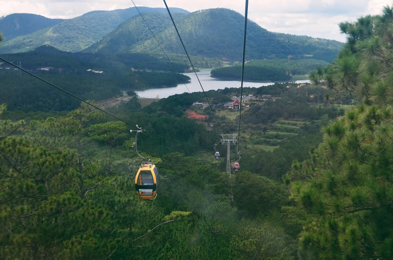 a cable car going through the mountains with a body of water