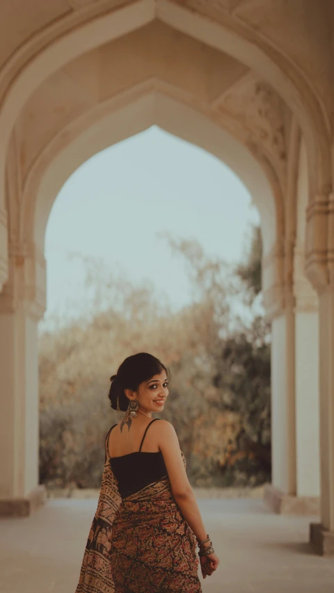 a woman in an ornate archway wearing a black top