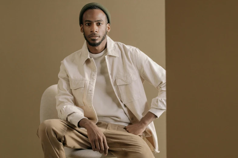 a man is sitting down wearing some brown pants