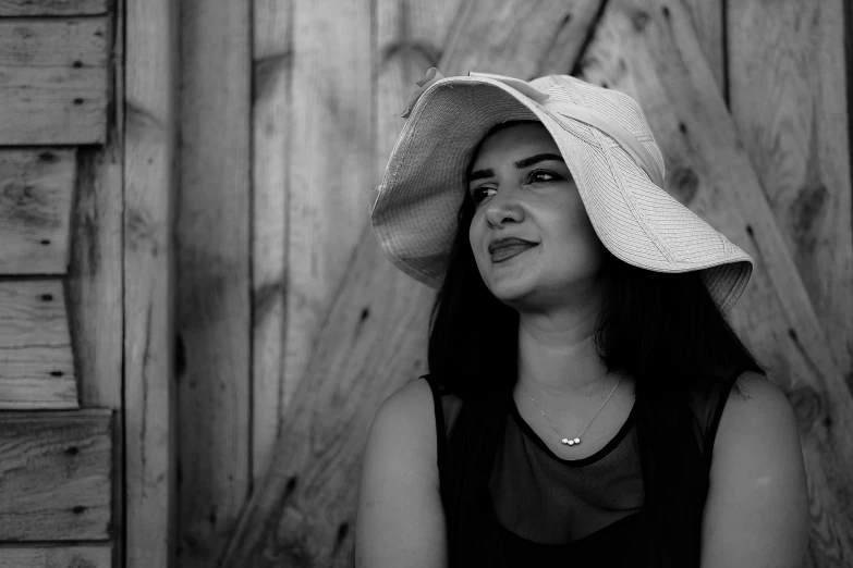 woman wearing white hat standing in front of wooden wall