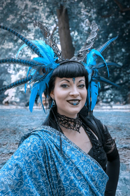 a woman dressed in a blue costume with large feathers