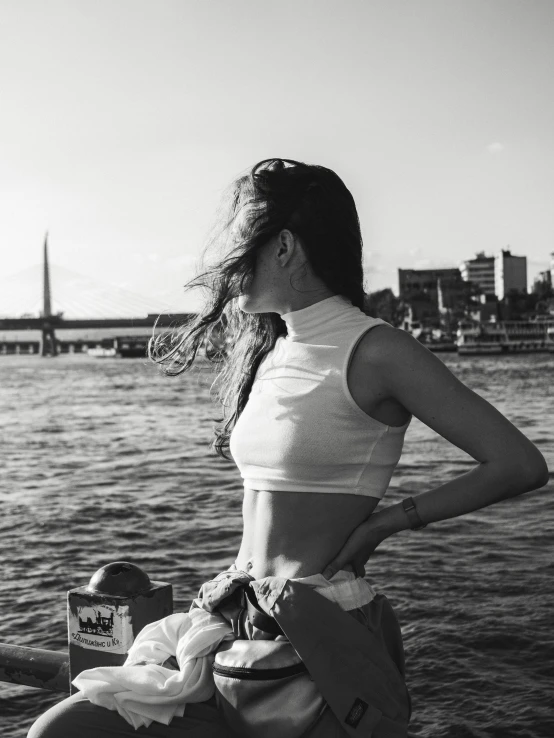 a woman in bathing suit sitting on boat next to water